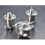 A George V silver three-piece condiment set, comprising salt cellar, pepperette and mustard, each of