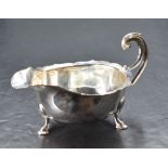 A George V silver gravy boat, of traditional design having generous spout opposed by double scroll