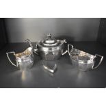 A three piece silver tea set of tapered oval form having pressed decoration to rim, Chester 1921,