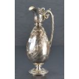 A Victorian silver ewer, of ovoid form with shaped spout and hinged cover over a body embossed