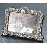 A Queen Elizabeth II silver mounted photograph frame, of shaped rectangular form embossed throughout