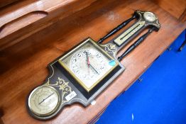 A vintage kitsch barometer with clock face