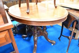 A Victorian mahogany oval top dining table having quadruple turned supports and carved legs