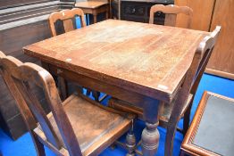 An early to mid 20th Century oak drawer leaf dining table and set of four similar chairs