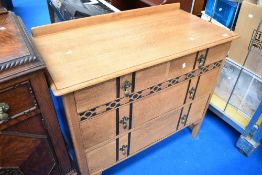 An early 20th Century golden oak bedroom chest with exposed detailing and brass drop handles,