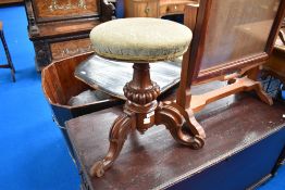 A Victorian mahogany piano stool having upholstered swivel seat