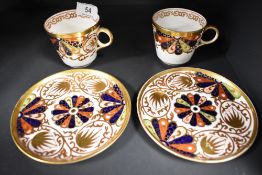 A pair of Copeland tea cup and saucer sets having an Imari palette pattern.