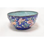 A small enamel bowl in a Chinese style being hand decorated with fruit and flower scenes 9cm wide.
