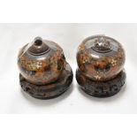 Two vintage Chinese cloisonné enamel lidded pots on carved wooden stands, having decoration of