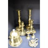 Three pairs of antique brass candlesticks with a chamber stick and condiment container.
