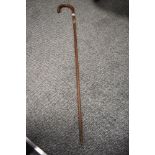 An antique textured wood walking cane having silver cuff to shaft and silver pips to handle.