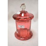 A Victorian cranberry glass sweet jar with a clear glass handle, small chips to rim and lid.