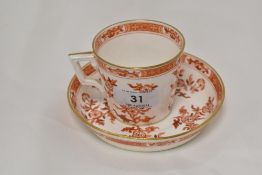 A Victorian Minton tea cup and saucer set in a red and gilt design, saucer having hair line cracks.