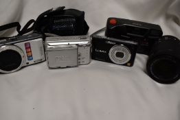 Four cameras and a lens. A hanimex EFP35, a Pentax Optio VS20, a Lumix FS9 and a Finepix A700
