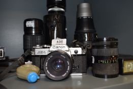 A Canon AE-1 camera with Canon FD 50mm 1;1,8 lens, a Canon FD 35-70mm 1;4 lens, a Canon FD 100mm 1: