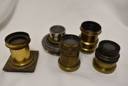 A box of five brass lenses with only Busch's Rapid Symetrical F8 named