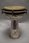 A 20th century Darbuka Tabla percussion drum with an embossed metal work body.