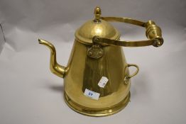A Victorian brass stove kettle with two pouring handles.