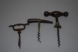 Three antique corkscrews or bottle openers.