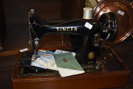 A 20th century electric Singer Sewing machine 99k with original case, accessories and manuals.