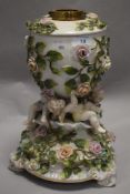 A Victorian German Sitzendorf type porcelain oil lamp base with cherub supports and floral