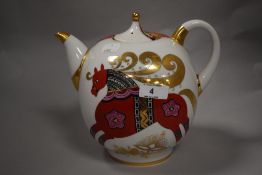A Losmonov Russian porcelain teapot, decorated with a stylised horse with gilt highlights, printed