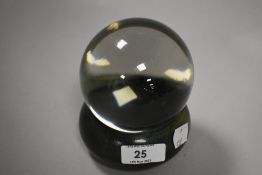 A crystal ball with turned and green stained wooden base