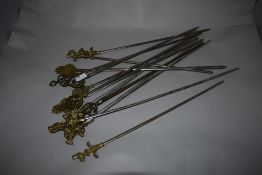 A selection of eastern brass topped meat skewers, the terminals with various motifs