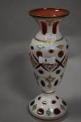 A 19th century Bohemian overlay glass vase, wheel-cut with apertures and painted with foliate