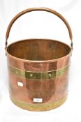 A vintage brass and copper coal bucket.