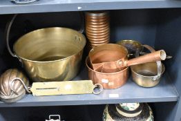 A selection of vintage copper and brass kitchenalia, including jam pan and jelly mould.