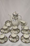 An Art Deco Royal Doulton partial coffee set, having vibrant flower and parrot transfer pattern,