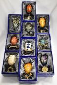 Ten decorative egg trinket boxes, most with stands, with boxes.
