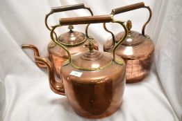 Two antique copper kettles and one vintage copper kettle.
