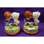 A pair of mid-century pottery figurines in the manner of Hummel, two kissing children with