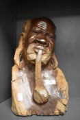 A Carved wood African bust, depicting man smoking a pipe.