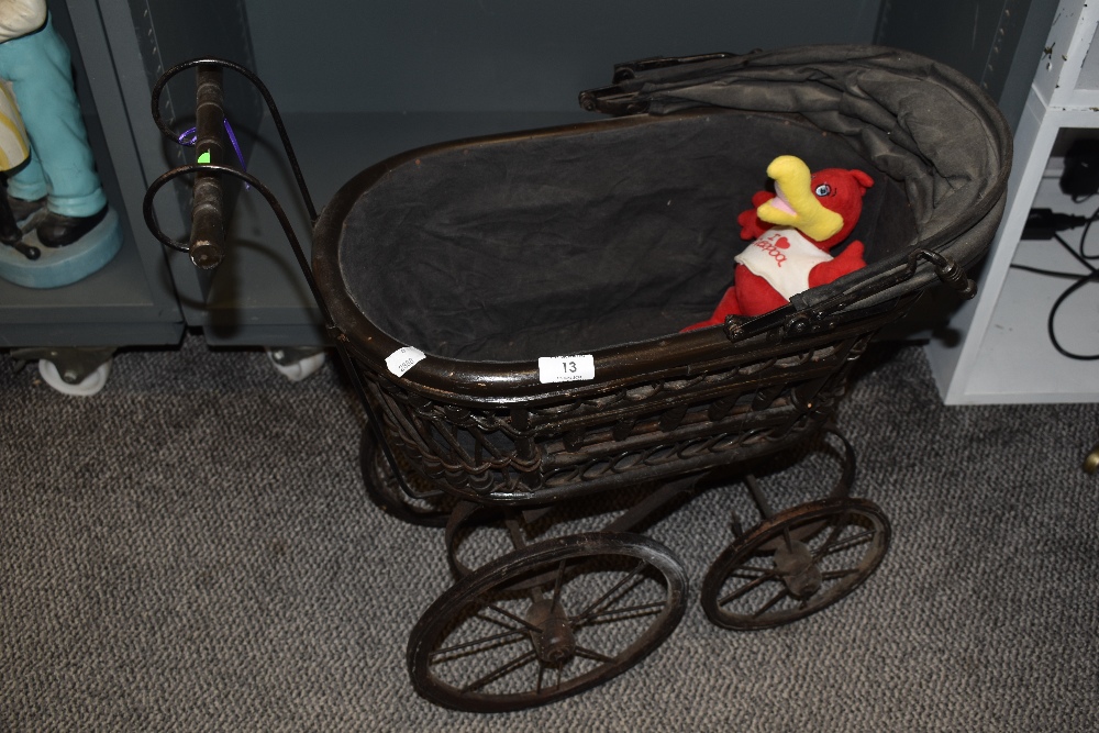 A vintage dolls pram of wood and metal.