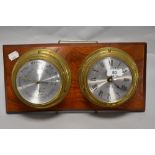 A mid century brass clock and barometer duo mounted on wooden plaque.
