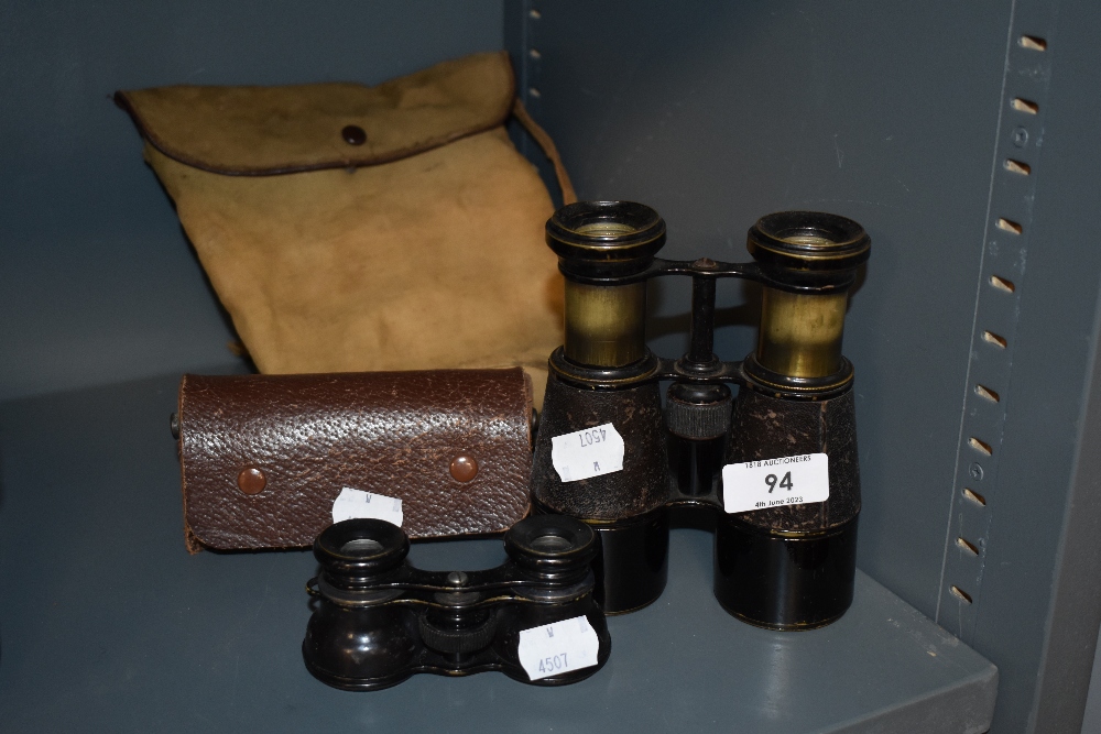 A pair of antique brass and leather clad binoculars and a similar smaller set.