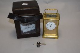 A late Victorian brass cased eight day French carriage clock, having bevelled glass to front, rear