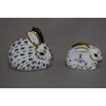 Two Royal Crown Derby rabbit paper weights, both having silver stoppers.