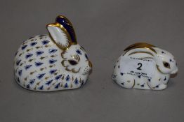 Two Royal Crown Derby rabbit paper weights, both having silver stoppers.