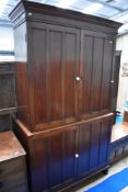 A 19th Century mahogany larder press cupboard in two sections, with panelled doors and pot handles