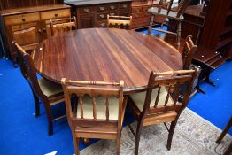 A modern hardwood 'tiger' style large circular dining table and set of six chairs