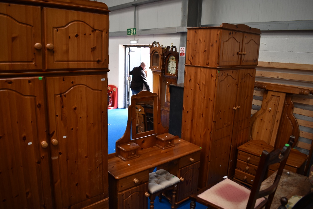 A modern pine bedroom suite comprising two wardobes, dressing table with stool, bed frame and pair