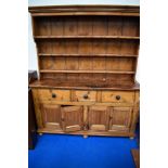 A 19th Century rustic pine dresser having three tier plate rack to back , three drawers and two