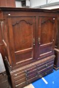 An 18th Century and later oak linen press/wardrobe with faux bottom and drawers, with just two short