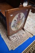 An early 20th Century oak framed firescreen with embroidered panel