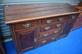 A Victorian mahogany sideboard having four central drawers flanked by cupboard all with brass drop