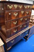 An 18th Century mahogany and walnut chest on stand having brass handles and escutcheons on